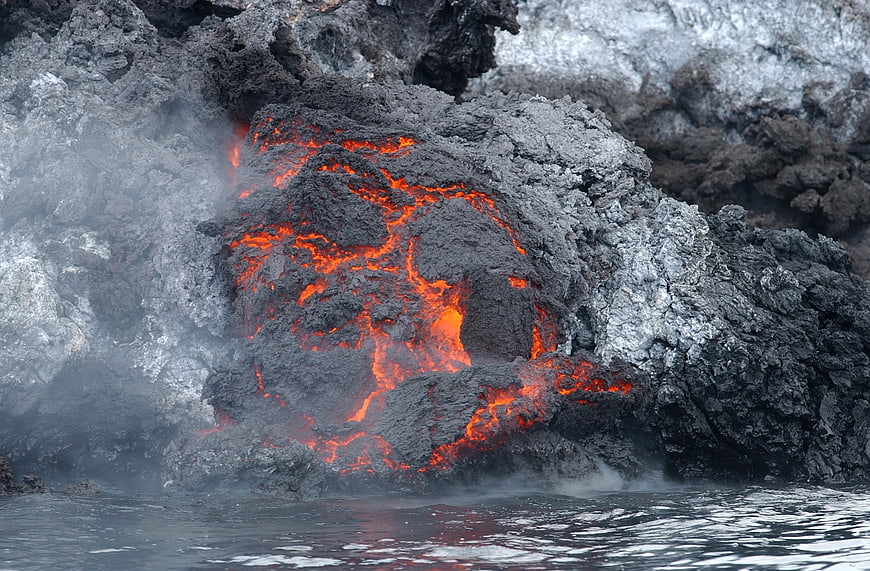 Volcanic Lava Flow Entering Ocean Water with Steam