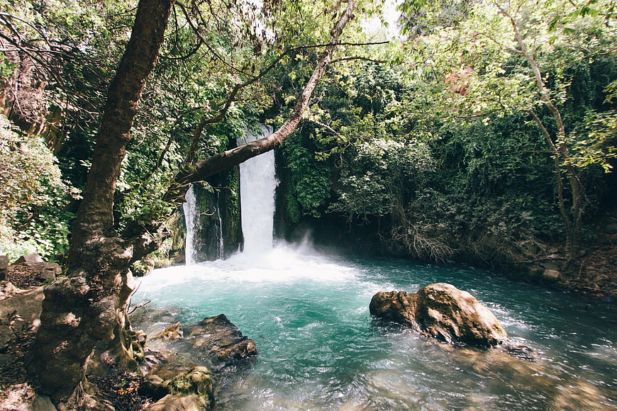 Serene waterfall cascading into turquoise pool in lush forest