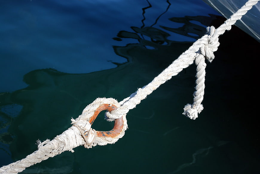 White Rope with Rusty Metal Ring on Blue Water