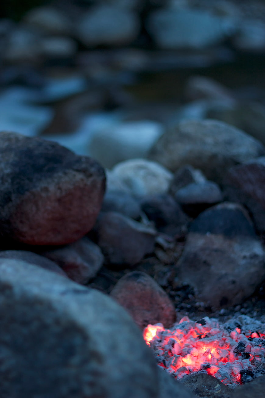 Glowing Campfire Embers Surrounded by River Stones