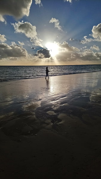 Silhouette of Child Walking on Beach at Sunset