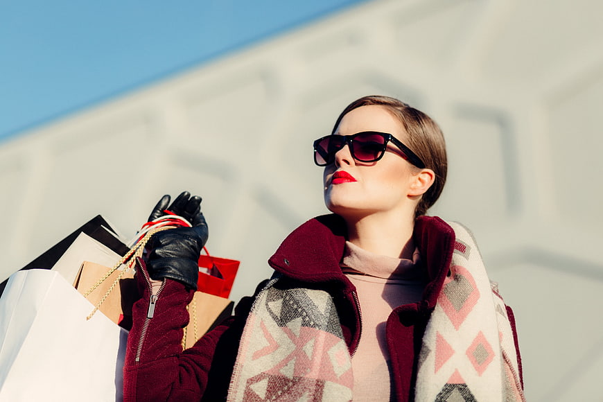 Stylish woman with shopping bags and sunglasses outdoors