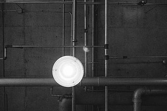 Industrial Pipes and Light Fixture on Concrete Wall