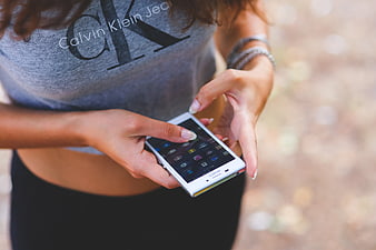 Woman using white smartphone outdoors