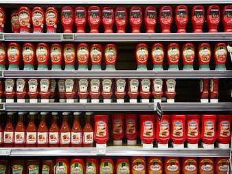 Supermarket shelf display of assorted ketchup bottles