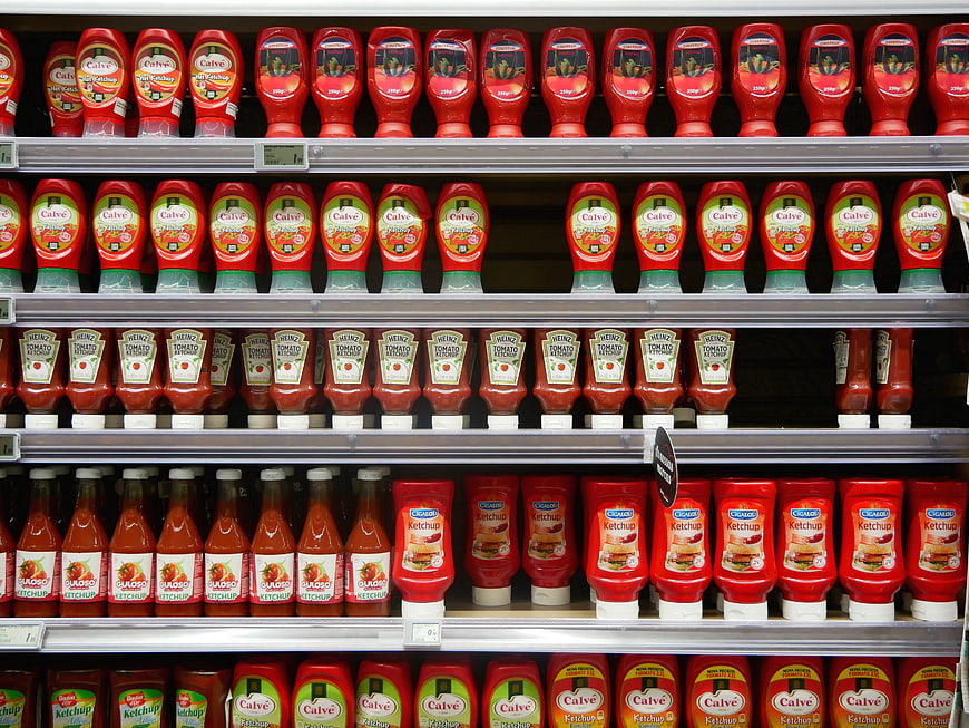 Supermarket shelf display of assorted ketchup bottles