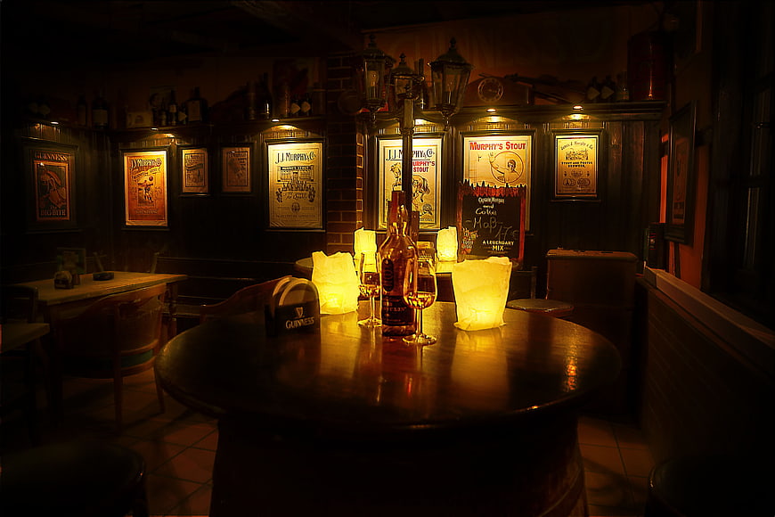 Dimly Lit Traditional Irish Pub Interior With Beer Bottles And Vintage Posters