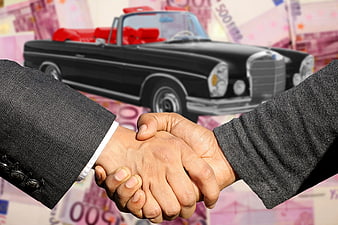 Business handshake over classic car and money background