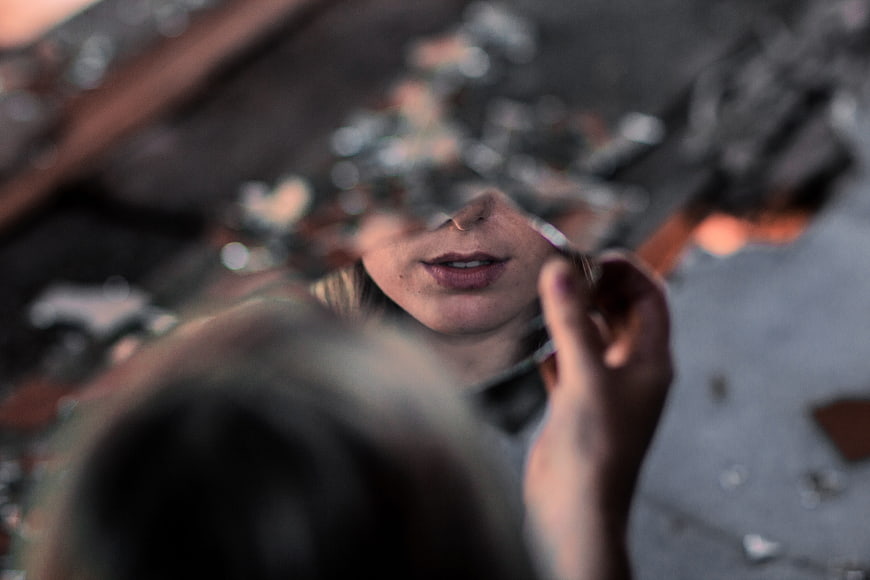 Woman's Face Reflected in Shattered Mirror with Heavy Bokeh