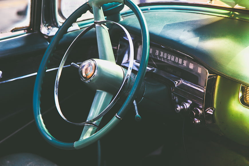 Vintage Green Car Interior with Steering Wheel and Dashboard