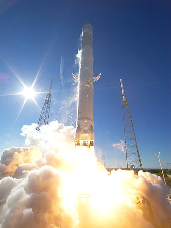 Space rocket launch with bright exhaust and blue sky