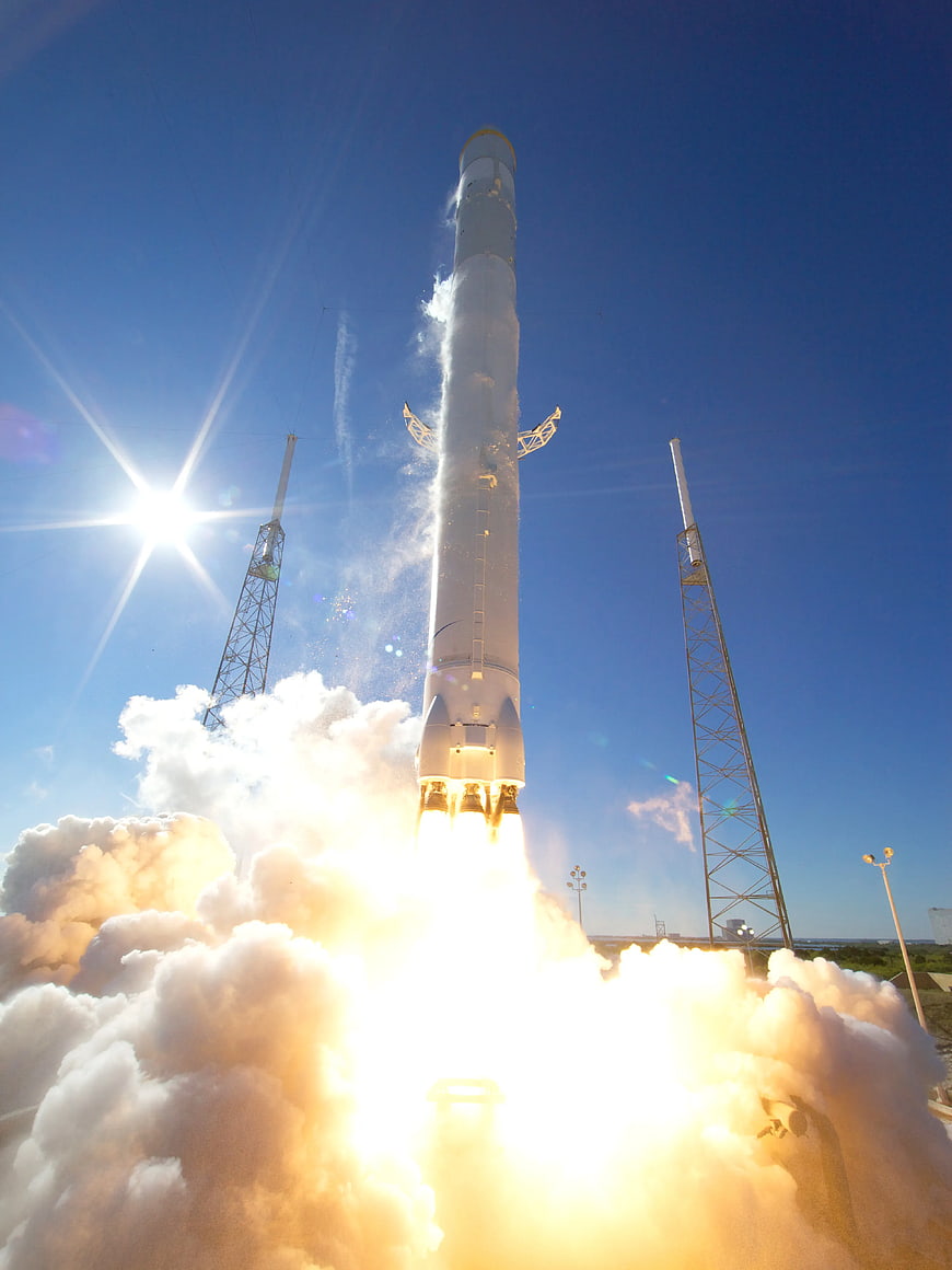 Space rocket launch with bright exhaust and blue sky