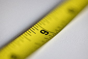 Close-up of yellow measuring tape on white surface