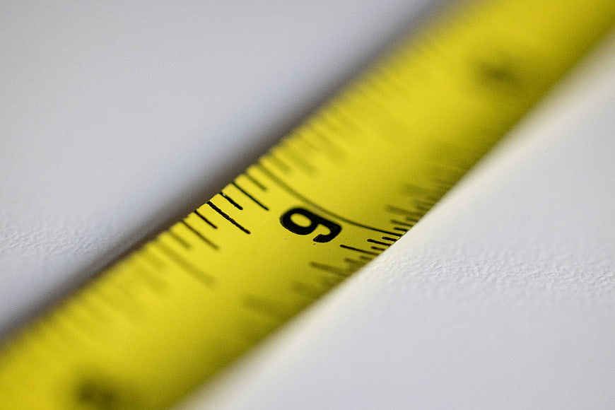 Close-up of yellow measuring tape on white surface