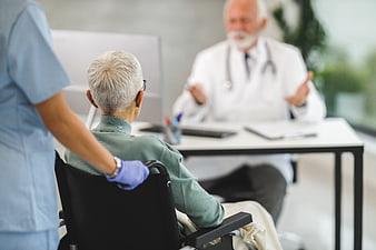 Senior patient in wheelchair consulting with doctor
