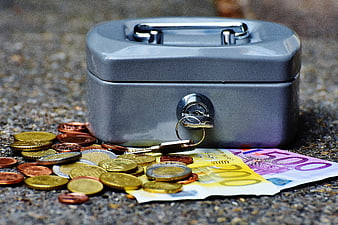 Gray Cash Box with Euro Bills and Coins on Asphalt
