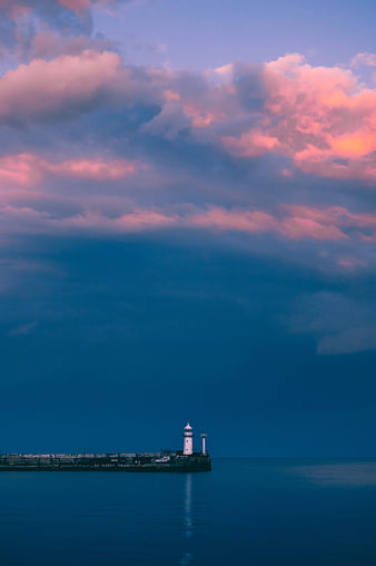 Lighthouse on Breakwater at Dusk with Dramatic Pink and Blue Clouds