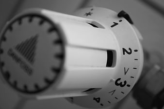 Close-up of a white thermostat dial with temperature settings
