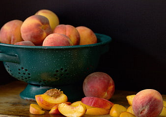 Fresh Peaches in Green Colander on Wooden Table