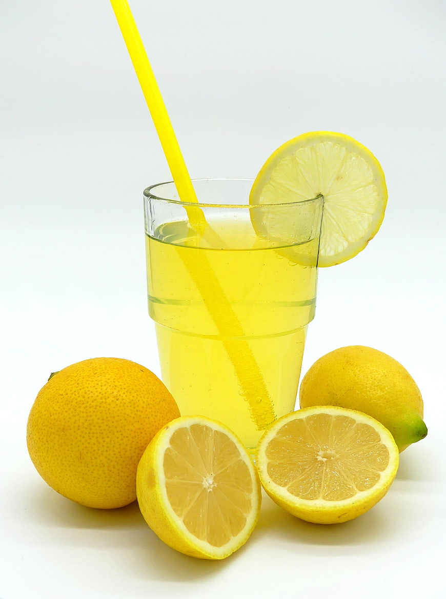 Fresh Lemonade with Straw and Lemons on White Background