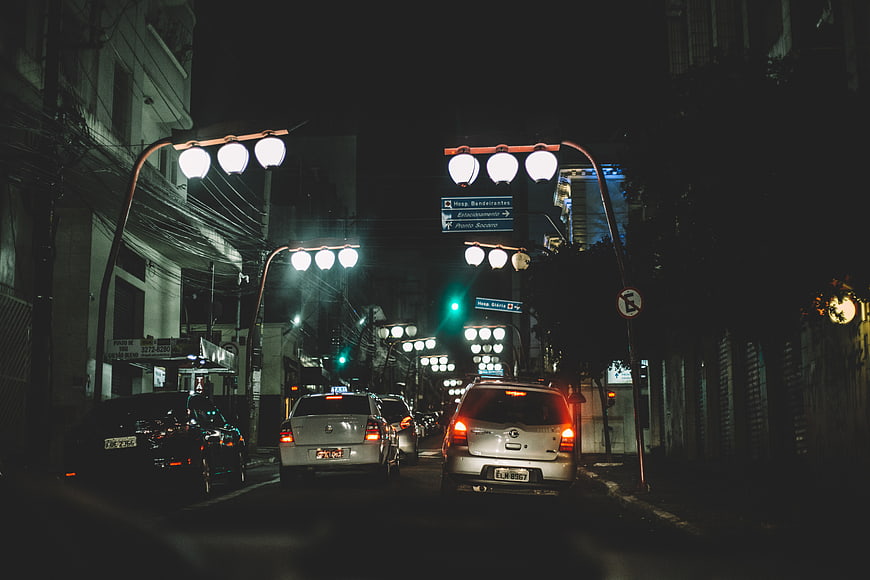 Night traffic on city street with streetlights and cars