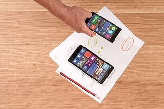 Windows Phone wireframes on paper desk with hand