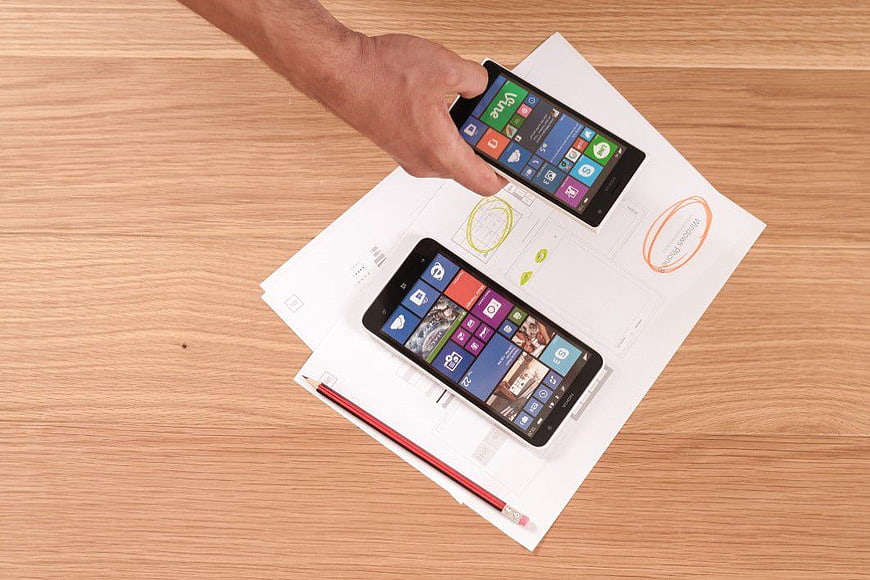 Windows Phone wireframes on paper desk with hand