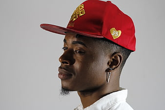 Young man in profile wearing red cap and white shirt