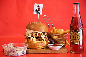 Korean Fried Chicken Burger with Fries and Soda on Red Background