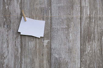Blank lined paper on clothespin against rustic wood background