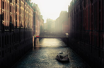 Tourist boat on Hamburg Speicherstadt canal at sunset