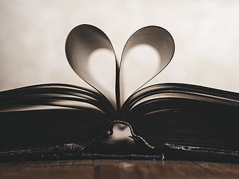 Open Book with Heart Shape Pages on Wooden Table