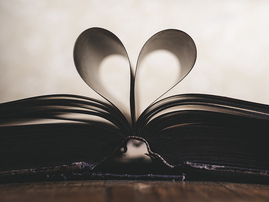 Open Book with Heart Shape Pages on Wooden Table