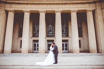 Bride and groom kissing in front of historic post office