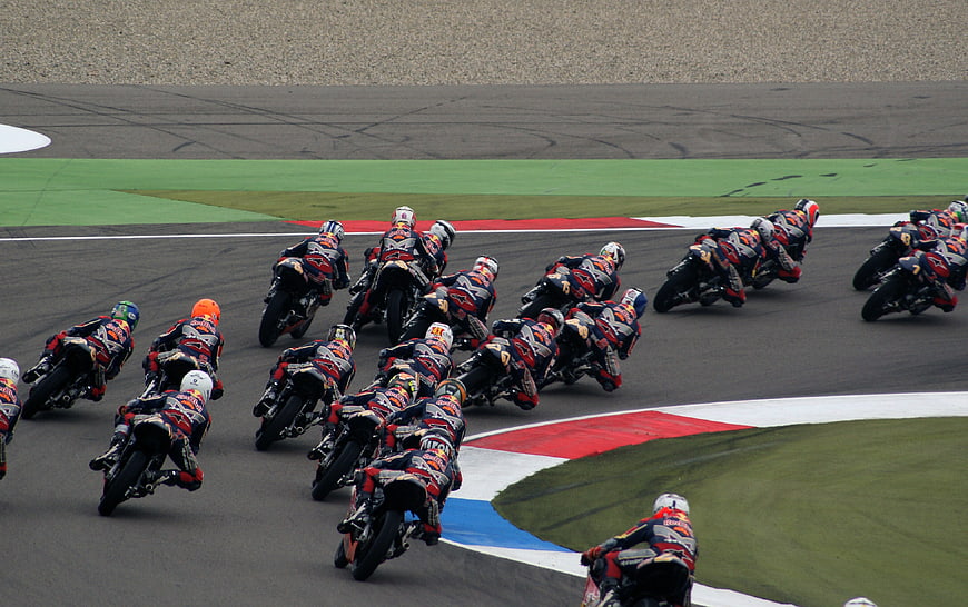 Motorcycle racers leaning into a turn on a race track