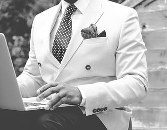 Businessman in white suit typing on laptop