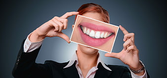 Businesswoman holding photo of perfect smile for dental care concept