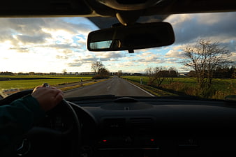 Driver's POV of a car ride on a rural road at sunset