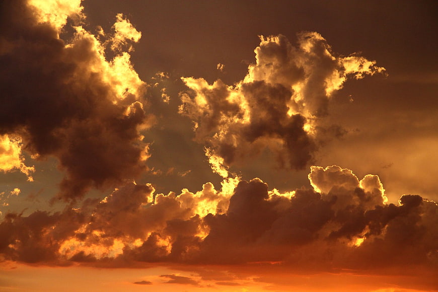 Dramatic golden hour clouds with fiery orange sunset sky