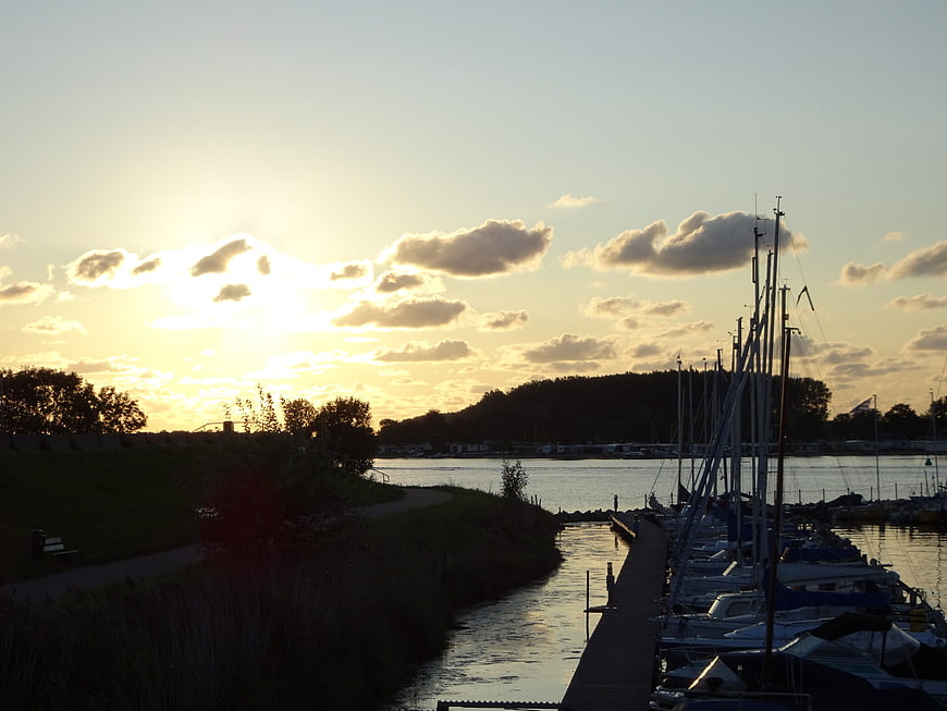 Sunset over marina with sailboats and calm water