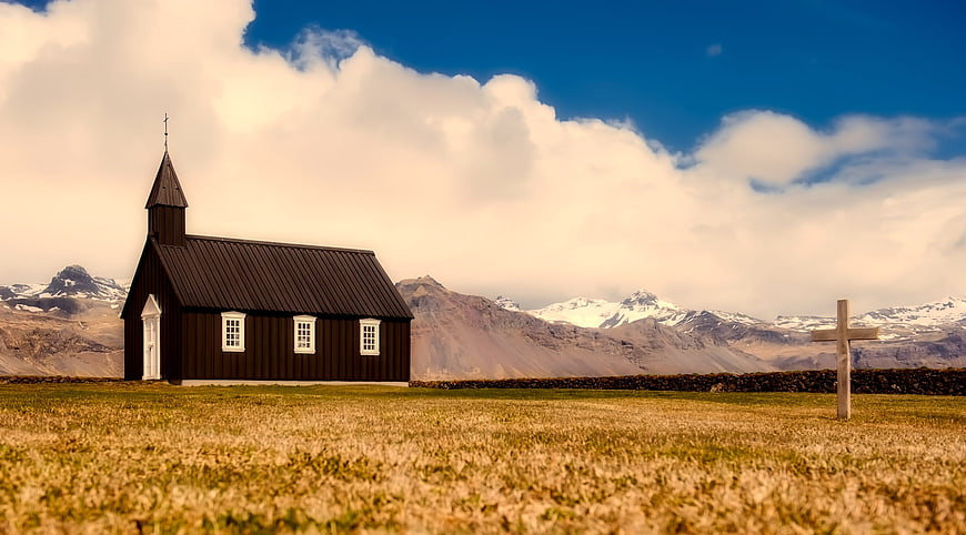 Black Church in Iceland with Mountains and Blue Sky