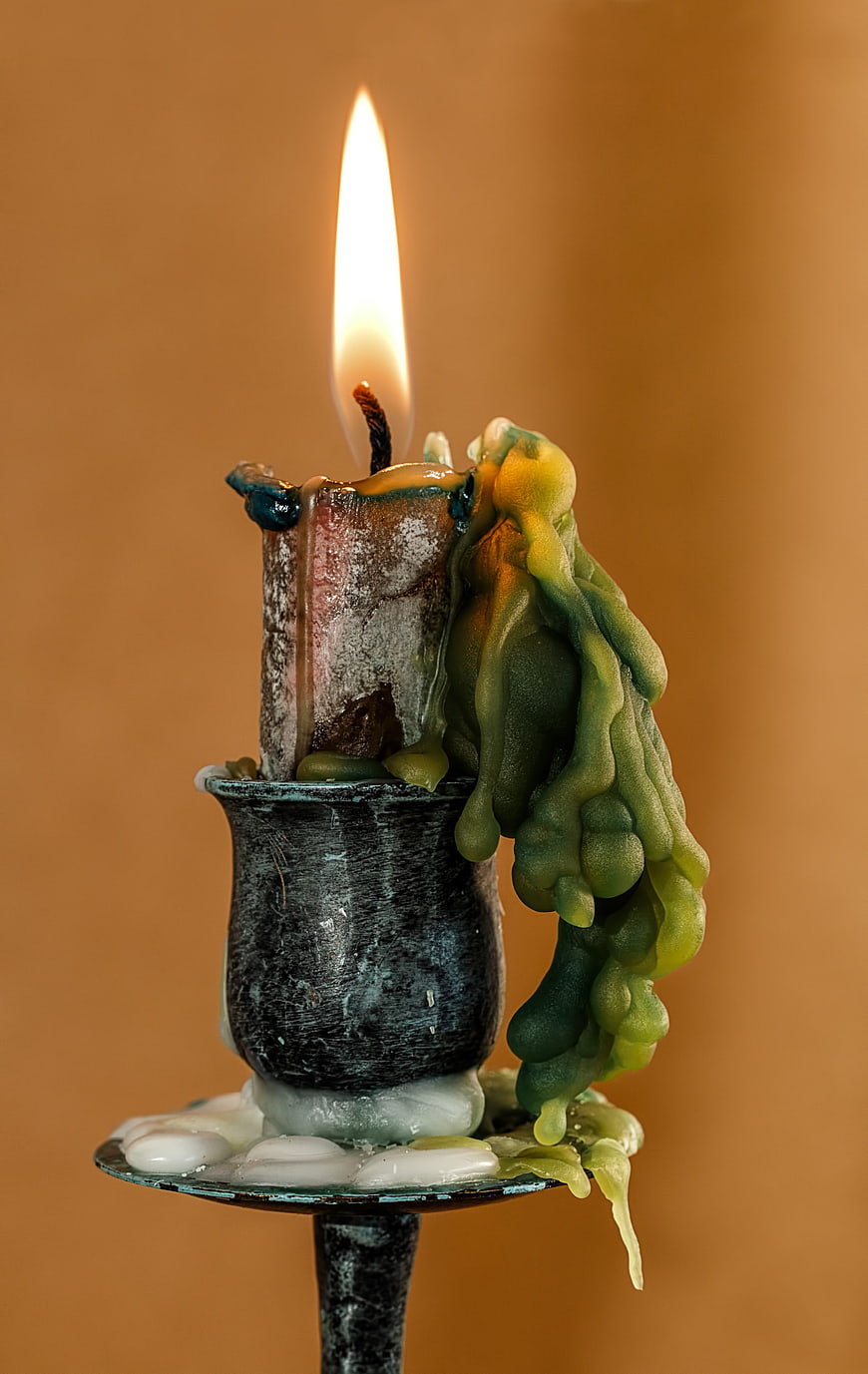 Burning Green Candle with Melted Wax in Vintage Holder