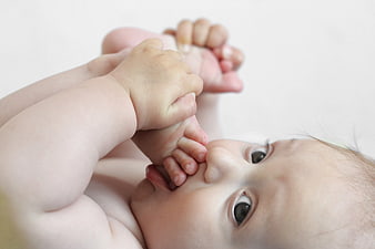 Cute Baby Lying Down Sucking Foot Close Up