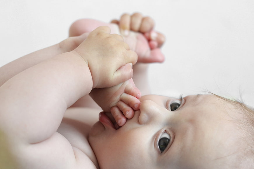 Cute Baby Lying Down Sucking Foot Close Up