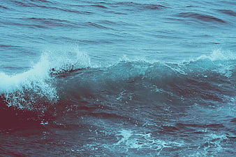 Cinematic crashing ocean wave with teal and red color grading