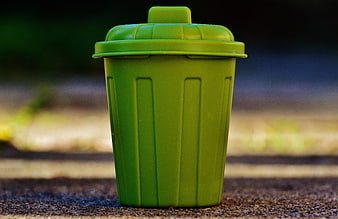 Green Miniature Trash Can Toy on Asphalt