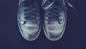 Silver metallic sneakers on dark blue background