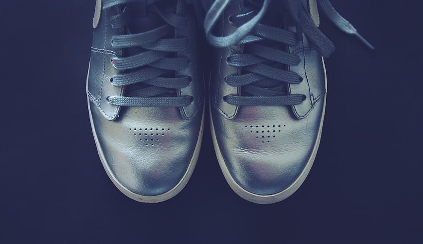 Silver metallic sneakers on dark blue background