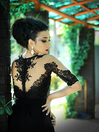 Elegant woman in black lace dress with dramatic makeup