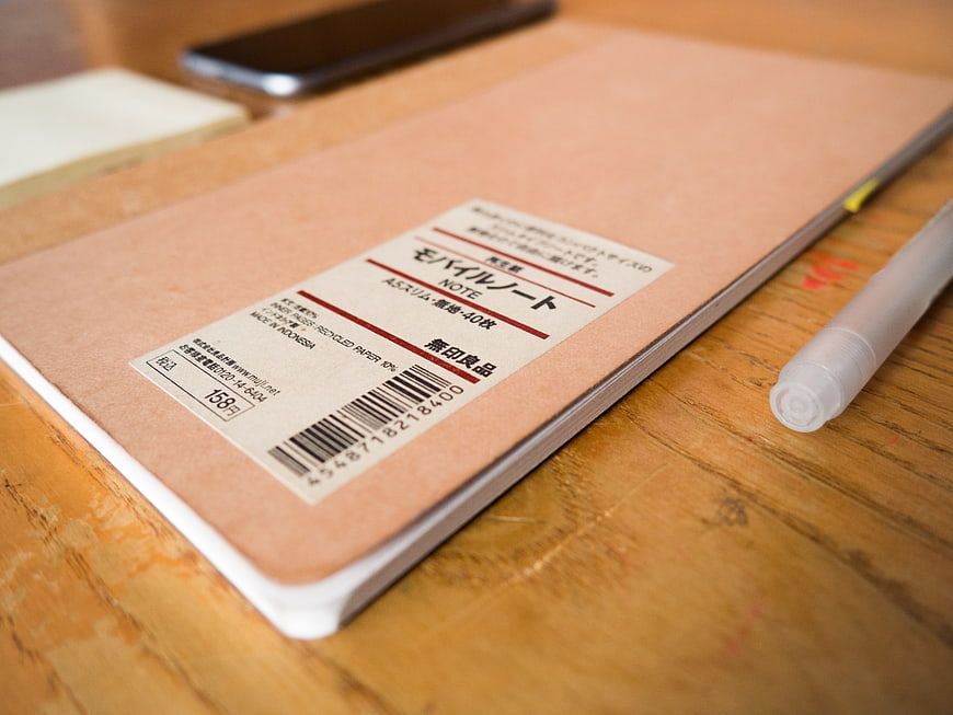 Minimalist Peach Notebook on Wooden Desk with Pen